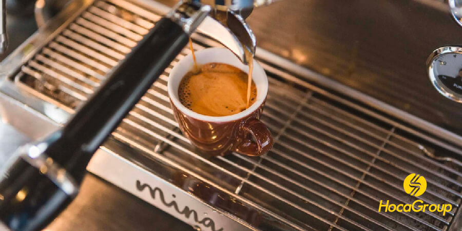 Một máy pha cà phê espresso đang hoạt động trong một quán cà phê